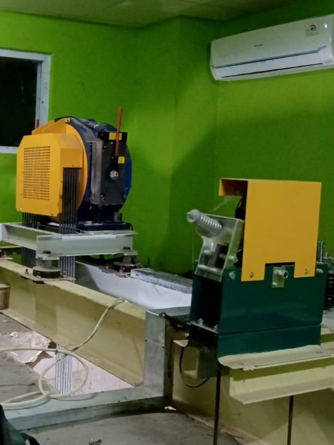 Teknisi profesional sedang melakukan pemeliharaan lift di gedung perkantoran modern dengan seragam biru dan alat canggih